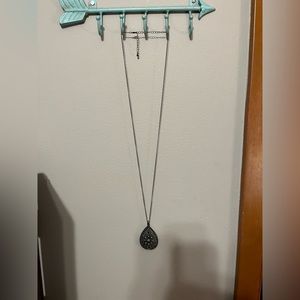 Long silver necklace with detailed oval bottom
